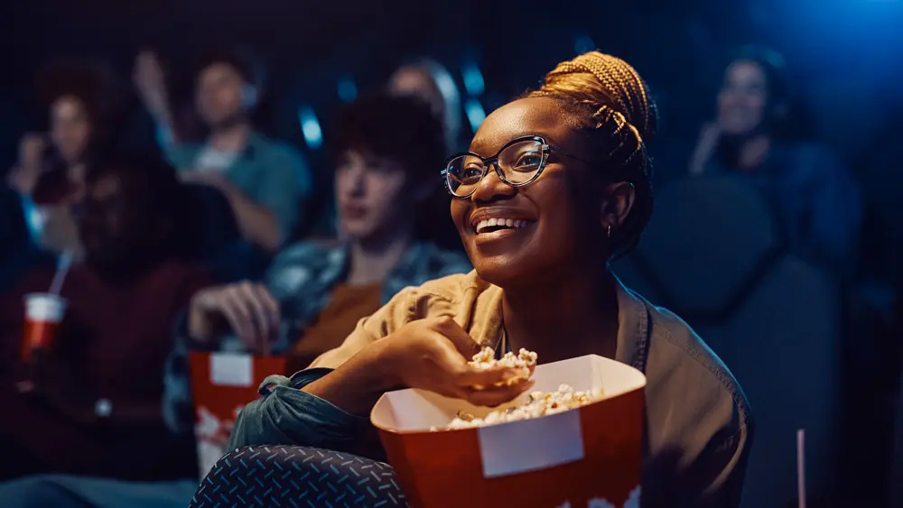 happy-black-woman-eating-popcorn-while-watching-mo-2025-03-03-12-39-59-utc
